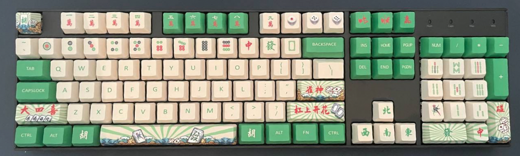 A full keyboard with number pads at the side, and many mahjong themed keycaps mirroring the playing cards